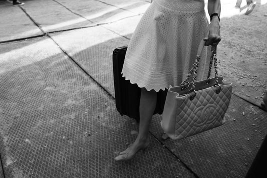 Woman in a white dress holding a handbag